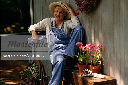 Porträt der Frau sitzt von Haus mit Gartenarbeit Supplies