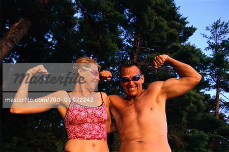 Portrait of Couple in Swimwear Flexing Muscles Outdoors