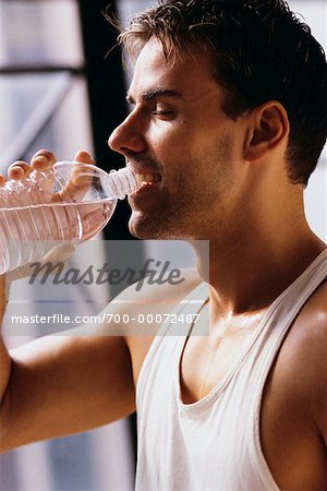 Profil von Man Standing in der Nähe von Fenster, Trinkwasser Flasche