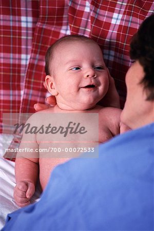 Mère de jouer avec le bébé sur le lit