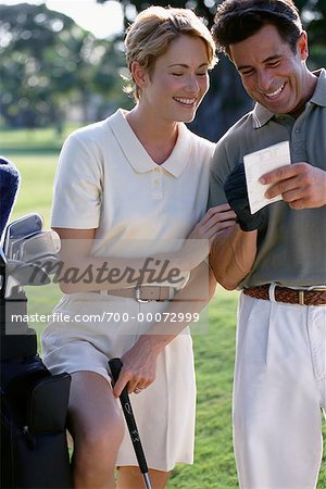 Couple sur le parcours de Golf, en regardant la carte de Score