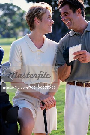 Paar auf Golfplatz mit Scorekarte, lachen
