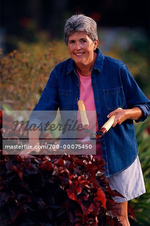 Portrait of Mature Woman Holding Hedge Clippers in Garden
