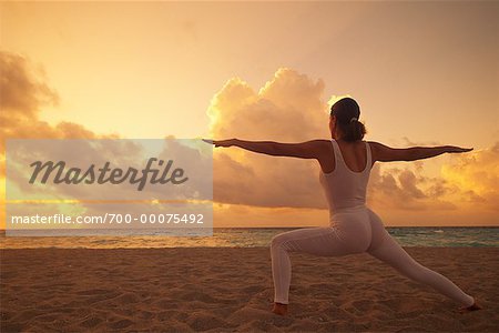 Back View of Woman Stretching on Beach at Sunset