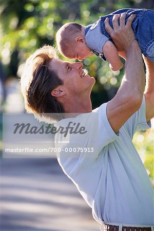 Father Holding Baby, Face to Face Outdoors