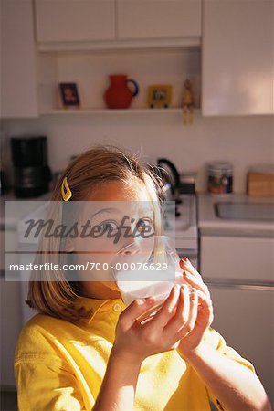 Portrait of Girl Drinking Glass Of Milk in Kitchen