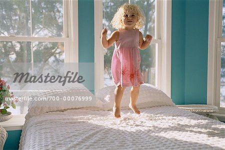 Portrait de jeune fille sautant sur le lit