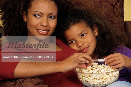 Mother and Daughter Sitting on Chair, Eating Popcorn