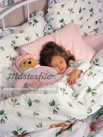 Mädchen mit Teddybär im Bett schlafen