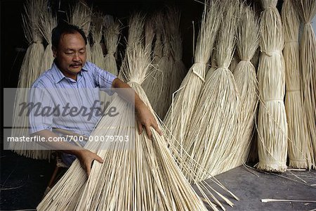 Mann Handling getrocknete Nipah Palm Blätter im Shop Teluk Intan, Malaysia