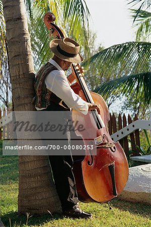 Homme penché sur Palm Tree jouant Double Bass Province de Santiago, Cuba