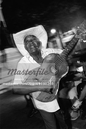 Portrait of Mature Man Smoking Cigar and Playing Guitar Outdoors At Night, Santiago de Cuba, Cuba