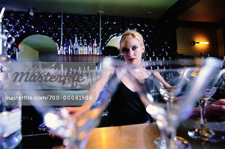 Portrait of Female Bartender at Bar with Close-Up of Martini Glasses