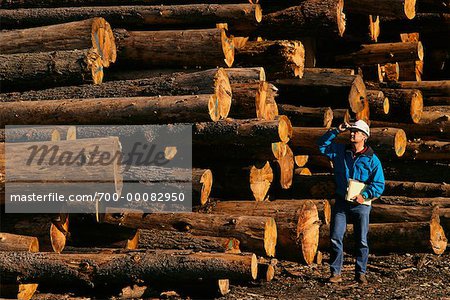 Worker with Cut and Stacked Logs