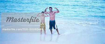 Portrait du père et fils en maillot de bain, Flexing Muscles sur la plage