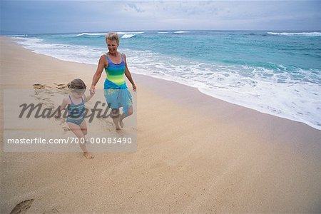 Grand-mère et petite-fille de marcher sur la plage, main dans la main