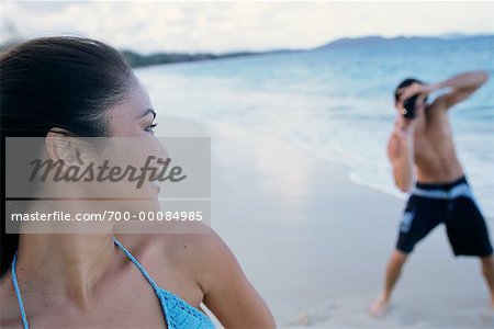 Couple en maillot de bain, l'homme prenant la photographie de femme sur la plage
