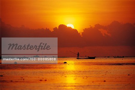 Silhouette d'une personne sur le bateau au coucher du soleil de Bali, Indonésie