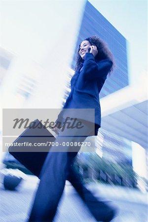 Businesswoman Walking Outdoors Using Cell Phone