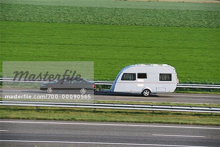 Voiture avec remorque sur autoroute