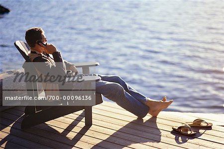 Person Sitting on Dock Using Cell Phone