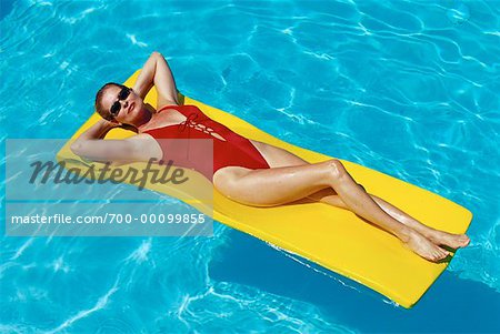 Frau liegend auf Luftmatratze im Pool