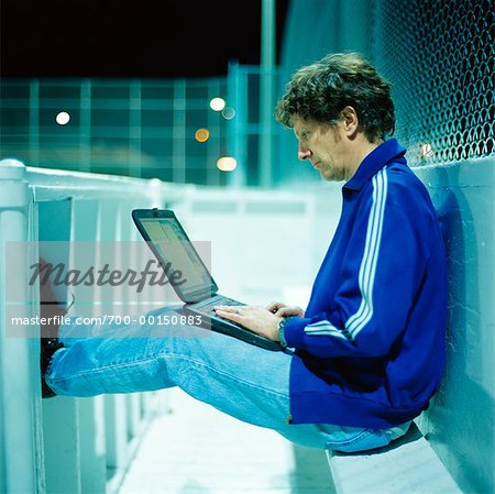 Man Using Laptop in Outdoor Ice Rink