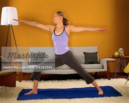 Femme pratiquant le Yoga dans son salon