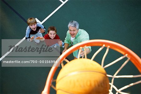 Vater und Söhne, die Basketball spielen
