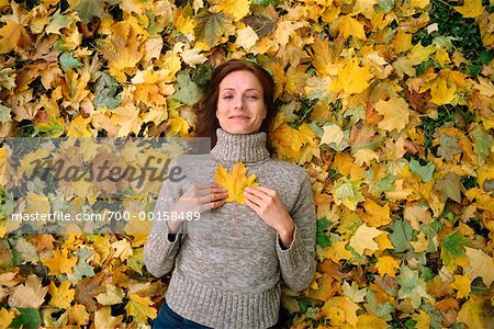 Femme couchée dans les feuilles d'automne