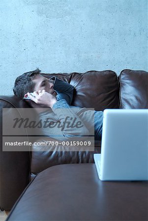 Homme couché sur le canapé, parlait au téléphone