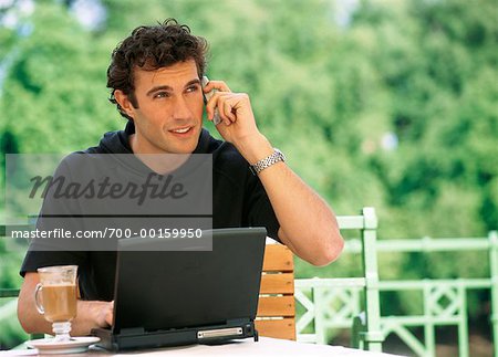 Man on Cell Phone With Laptop