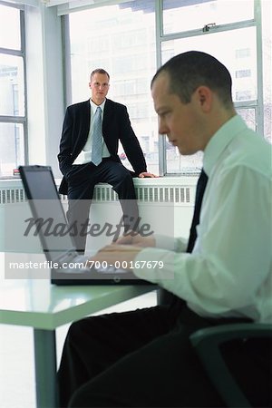 Businessman Watching Colleague Using Laptop Computer