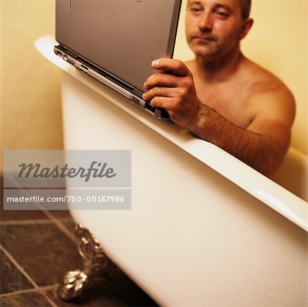 Mann mit Laptop-Computer in Badewanne