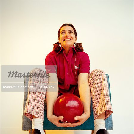 Woman Sitting in Chair Holding Bowling Ball