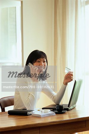 Femme d'affaires sur téléphone portable assis au bureau avec ordinateur portable Paris, France