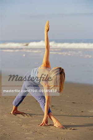 Femme faisant du Yoga sur la plage