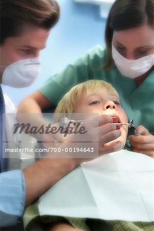 Boy Being Examined by Dentists