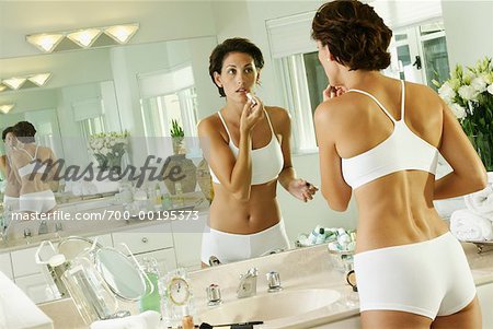 Woman Applying Lipstick in Bathroom