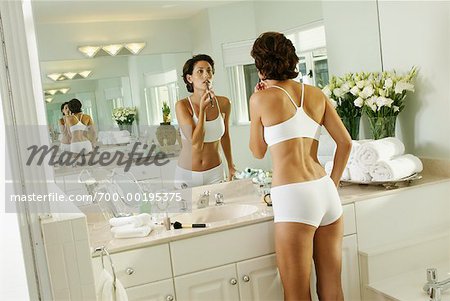 Woman Applying Make-up in Bathroom