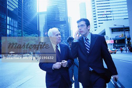 Businessmen with Cell Phone on Sidewalk
