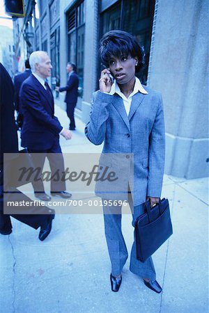 Businesswoman Standing on Sidewalk Using Cell Phone
