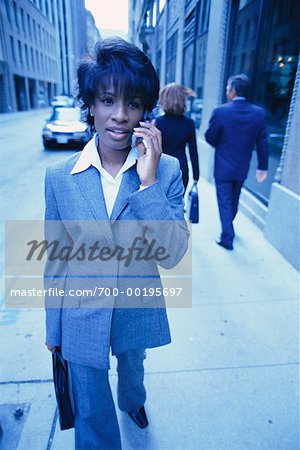 Femme d'affaires de marche de la rue vers le bas à l'aide de téléphone portable