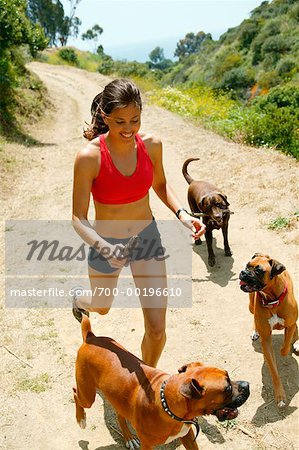 Femme en cours d'exécution avec des chiens