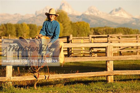Femme assise sur la clôture