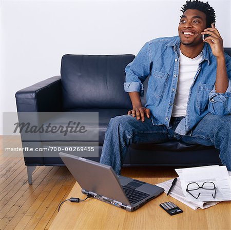 Mann mit Laptop-Computer mit Handy