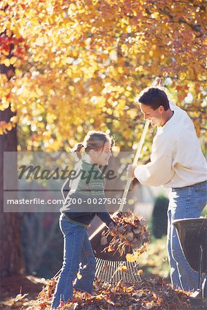 Father and Daughter Raking Leaves