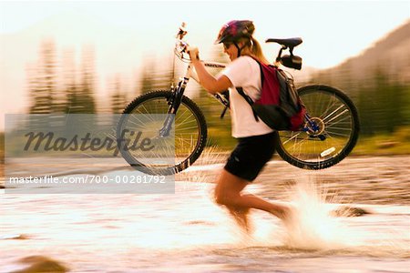 Woman Crossing River with Mountain Bike