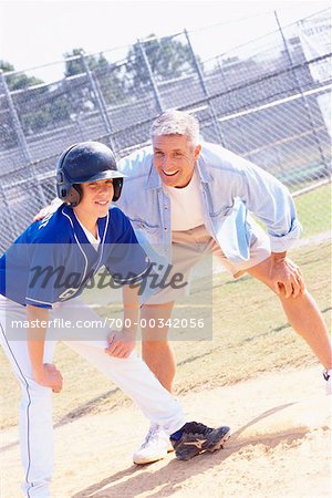 Boy with Coach on Baseball Diamond