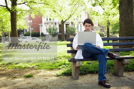 Mann sitzt auf einer Parkbank